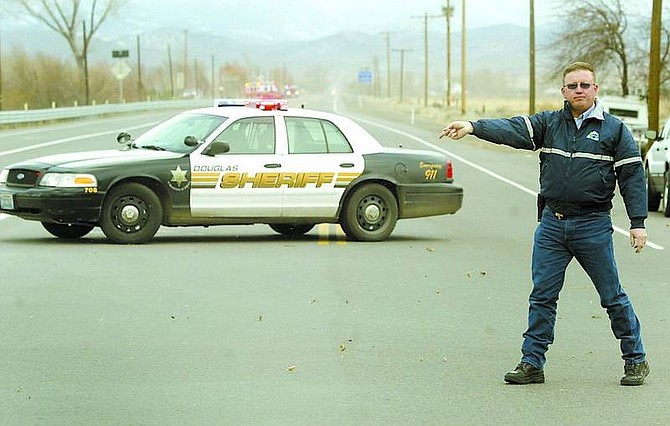 Shannon Litz/Nevada Appeal News Service Douglas County Code Enforcement Officer Jay Hoogestraat directs traffic at Highway 88 and Centerville Lane on Thursday afternoon. The road was closed from Centerville to Kimmerling Road because high winds were threatening to topple power poles.