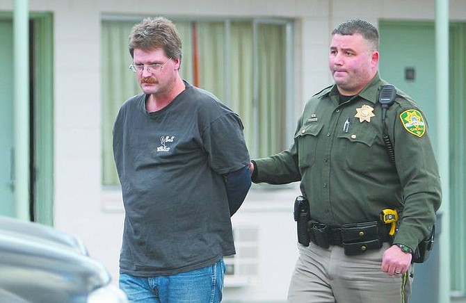 Cathleen Allison/Nevada Appeal Carson City Sheriff&#039;s Deputy Dan Ochsenschlager leads Robert Swindall, 39, of Gardnerville, into a patrol car Tuesday night outside the Roundhouse Inn. The suspect allegedly held up the Chevron gas station at N. Carson and W. William streets.