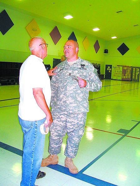 Karen Woodmansee/Nevada AppealPoll worker Chuck Beal talks to 1st Sgt. Harry House after House cast his vote Tuesday at Sutro Elementary School in Dayton.