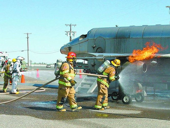 Hose teams quench the propane flames of a simulated fire on the Mobile Aircrafta Firefighting Training Device.  MC2 Doug Harvey/NAS Fallon