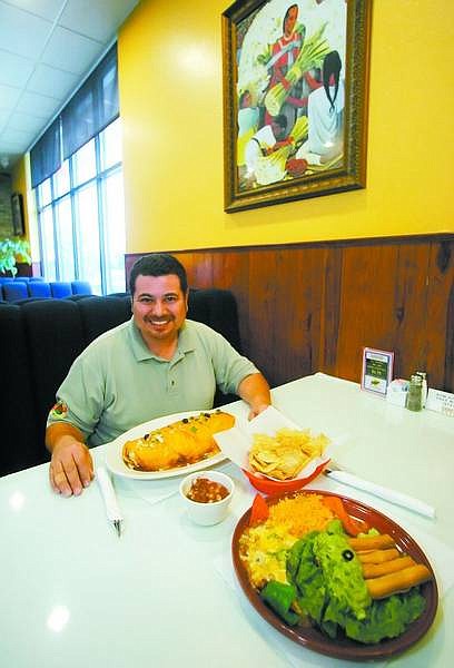 BRAD HORN/Nevada Appeal Juan Salazar Jr. sits by a Super Juan dish and an order of taquitos at Juan&#039;s Mexican Grill&#039;s new location at the Comstock Casino on Wednesday.