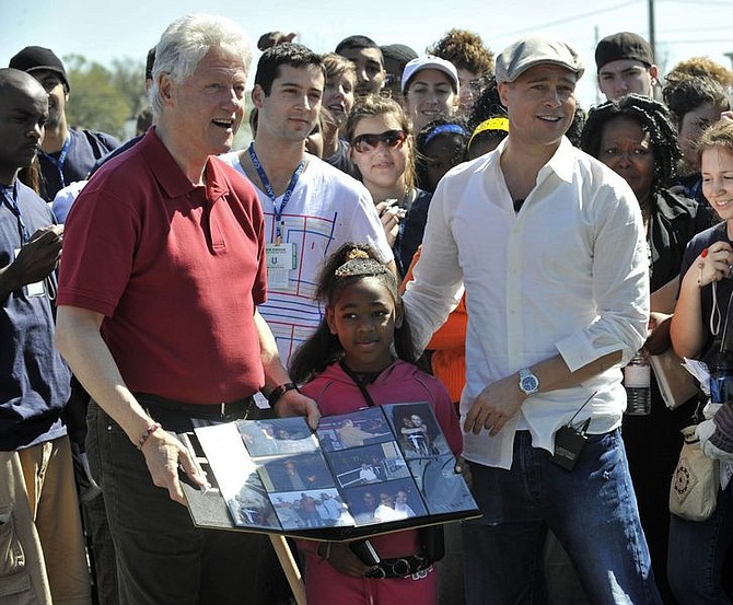 President Bill Clinton, left, hosting his Clinton Global Initiative University, and actor Brad Pitt, right, founder of the Make It Right Foundation, pose with DeeCarla Rogers while they greet volunteers and break ground for new homes in the Lower Ninth Ward, New Orleans, Sunday, March 16, 2008. (AP Photo/Cheryl Gerber)