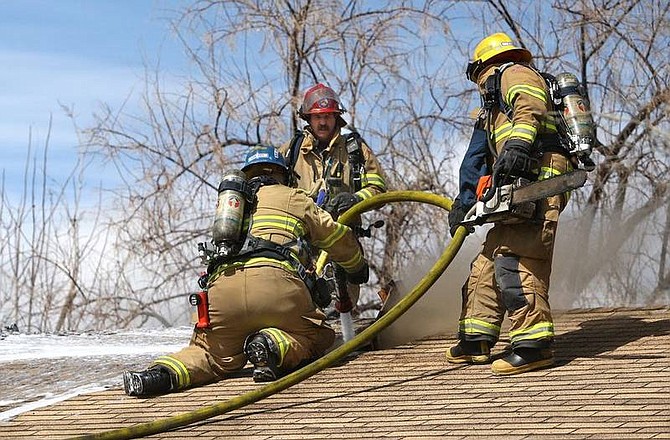 Cathleen Allison/Nevada AppealCarson City firefighters work to extinguish a house fire on Tamarisk Street on Thursday afternoon.