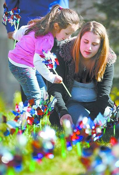 Cathleen Allison/Nevada AppealCarson High School senior Alexandra Mercer helps Rebekah Rhea, 5, place pinwheels on the Legislative lawn Tuesday afternoon as part of Child Abuse Awareness Month. The 492 pinwheels represent investigated cases of child abuse in Carson City in 2007.