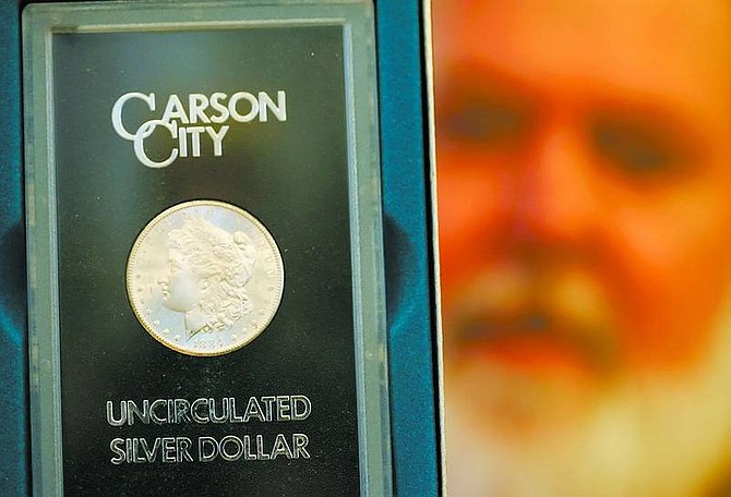 BRAD HORN/Nevada Appeal Joel Mitchell, owner of Old Mint Coin &amp; Bullion, holds a 1884 Carson City Morgan Dollar.