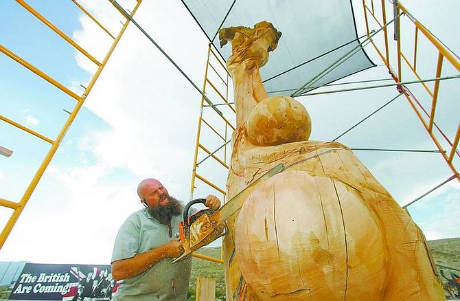 BRAD HORN/Nevada AppealMatthew &#039;Timeless&#039; Welter carves the shield into his 30-foot-tall wooden Statue of Liberty sculpture for his Burning Man art installation on Sunday. He is doing the work at his Carson City store Timeless Sculptures.