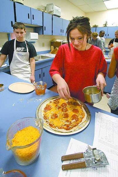 Kim Lamb CCHS senior Ashley Nunn, right works on her pizza project for the day during culinary class as junior Stefen Martinez watches.