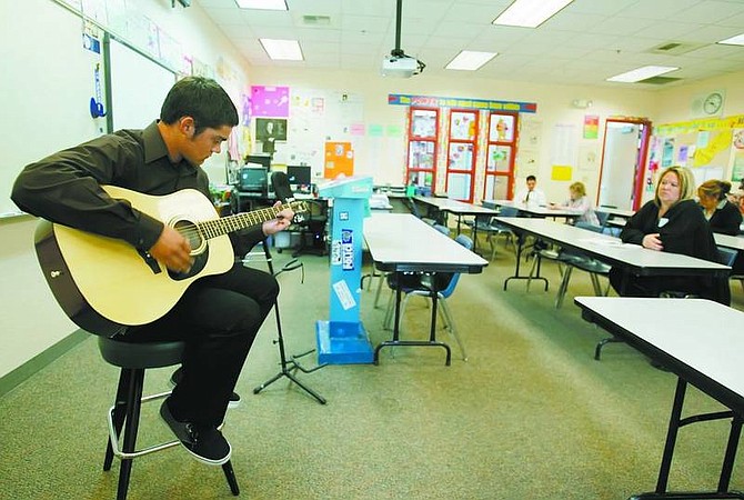BRAD HORN/Nevada Appeal Stephen Sawyers plays a Pearl Jam song for the judges during his senior project presentation at Carson High School on Wednesday. Sawyers learned to play guitar and read music for his project.
