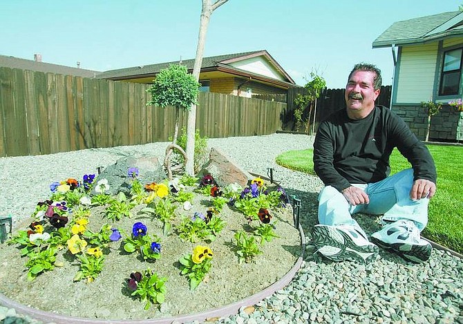 BRAD HORN/Nevada Appeal David Rhines, owner of DR Landscaping, sits in the front yard of his recently landscaped Carson City property on Thursday.