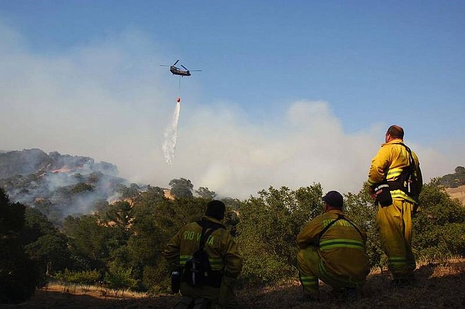 AP Photo/Eric PeraltaFirefighters from Rio Vista, Calif., overlook a helicopter water drop at a wildfire in Green Valley Calif., Sunday, June 22nd. 2008. The fire has consumed more than 3500 acres in Napa and Solano county.