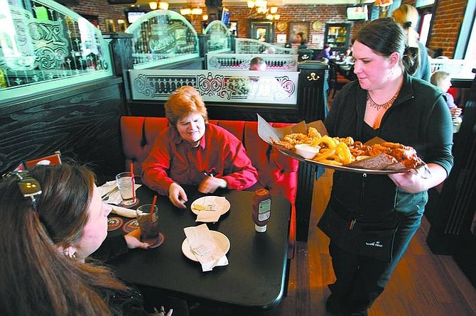 Cathleen Allison/Nevada Appeal Firkin&#039; and Fox waitress Erin Martinelli serves lunch to Jennifer Westphal and Barbara Durante on Wednesday afternoon. The restaurant is one of many local businesses offering food and drink specials for Sunday&#039;s Super Bowl. At right, patrons won&#039;t miss a minute of the big game at Firkin&#039; and Fox with the restaurant&#039;s 15 HD TVs, in addition to the three in the restrooms.