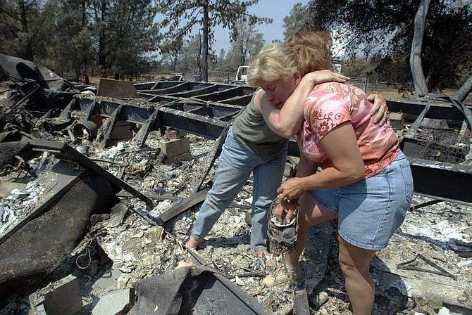 AP Photo//Chico Enterprise-Record, Jason Halleyrlando, left, consoles Chanter Johnson after finding her mom&#039;s ring in the remains of Johnson&#039;s home that burned to ashes as people begin to return home to see the remains on day four of the Humboldt Fire on Saturday, June 14, 2008 in Paradise, CA.