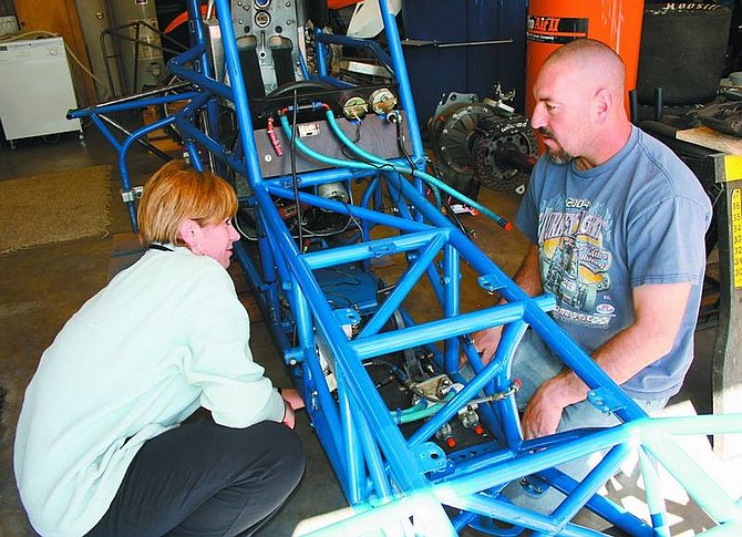 Rhonda Costa-Landers/Nevada Appeal  DNA Racing teammates Amy Barnes and Eric Silsby work on the chassis of Silsby&#039;s supermodified racecar recently in preparation for the 2008 Supermodified Racing Association season. Silsby runs the No. 66, Barnes will be in the No. 67.