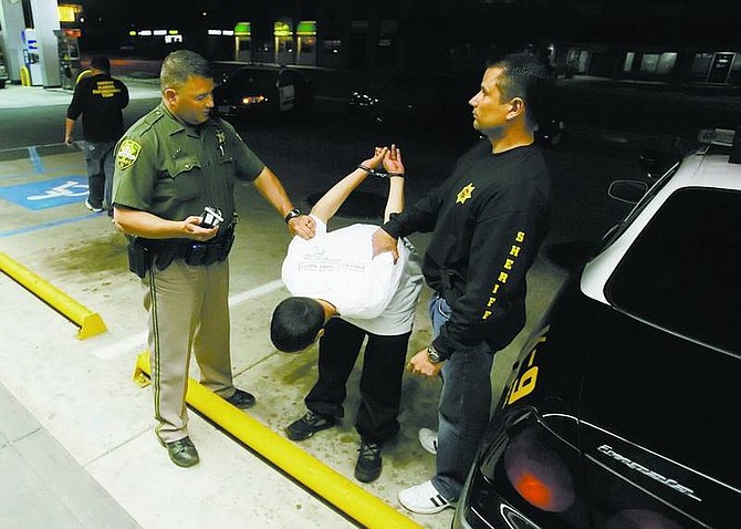 BRAD HORN/Nevada Appeal Carson City Sheriff&#039;s deputies Dan Ochsenschlager, left, K-9 Unit, and Sal Acosta attempt to test a suspect&#039;s alcohol level with a Breathalyzer at AM/PM on Carson Street Thursday. While Carson City&#039;s population continues to climb, the occurrences of crime in the city over the past decade shows a mixed bag, with no rate of any particular crime rising every year in the past decade.