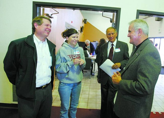 Gov. Jim Gibbons, right,  speaks with Carson High School senior Jessica Wilson, 17, and her father Jim, left, as another man looks on at Capital Christian Center on Saturday. Wilson turns 18 on May 16.  BRAD HORN/ Nevada Appeal