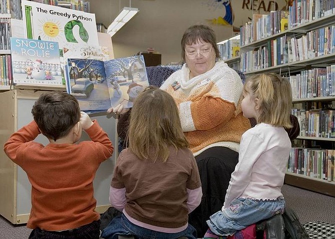 Christy Lattin/Nevada Appeal News Service Joyce Betts, the children&#039;s librarian at the Churchill County Public Library, reads a book to a small group of kids during story time. Enjoying the story, from left to right, are Brenton Baker, 3, Laura Smith, 4, and Lily Johnson, 5.