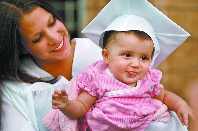 Cathleen Allison/Nevada Appeal Silver State Charter High School graduate Brittany Parra holds her 6-month-old daughter Destiny Grace Ledford after graduation Tuesday night at the Community Center.