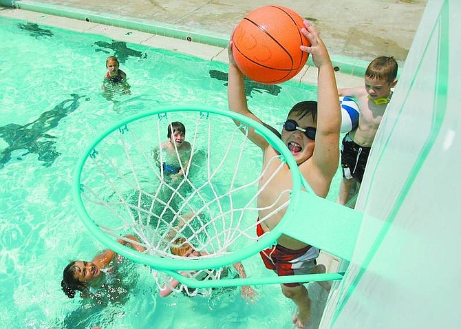 BRAD HORN/Nevada Appeal RJ Putt, 8, of Carson City, dunks at the pool at the Carson Aquatic Center on Wednesday. With temperatures soaring to record highs, people are finding ways to stay out of the sun.
