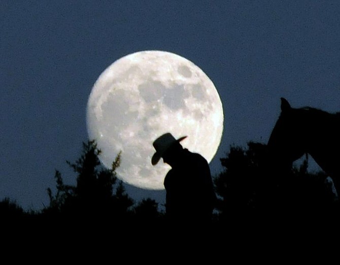 Orren Carmen of Grass Valley, Calif., walks his horse Kilt in front of a full moon during the second day of the Reno Rodeo Cattle Drive on Monday, June 16, 2008.  (AP Photo Nevada Appeal, Kevin Clifford).  ** MAGS OUT, NO SALES **