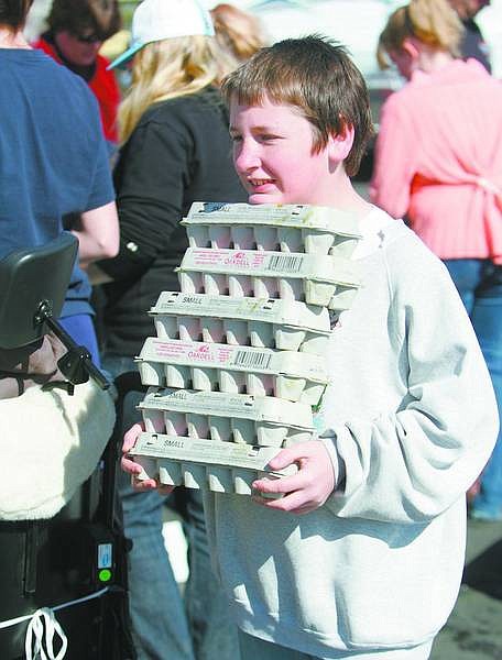 BRAD HORN/Nevada Appeal Travis Phalin, 12, carries dyed eggs at the Kiwanis Club sponsored egg dyeing event in preparation for today&#039;s Easter egg hunt at Governor&#039;s Field.