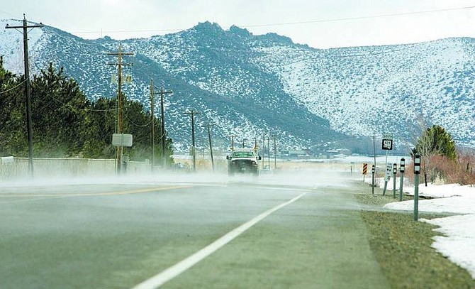 BRAD HORN/Nevada Appeal Traffic travels on Old Highway 395 in Washoe Valley while steam rises from the road as temperatures rise on Wednesday afternoon.