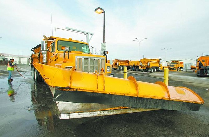 BRAD HORN/Nevada Appeal Victoria Brown, of Fallon, washes a snow plow at the Nevada Department of Transportation&#039;s yard on Stewart Street on Wednesday afternoon. Crews are readying for a storm expected to hit this weekend.