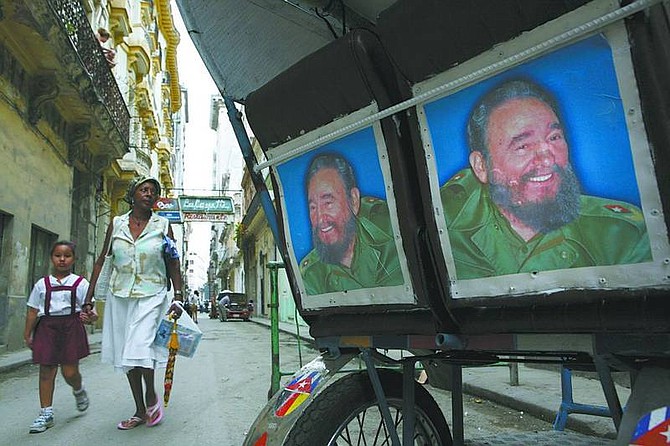 Ariana Cubillos/Associated Press A woman and a girl walk past a bicycle cart decorated with photographs of Cuban leader Fidel Castro in Havana, Tuesday. Castro resigned as Cuba&#039;s president after nearly a half-century in power, saying he will not accept a new term when the newly elected parliament meets on Sunday.