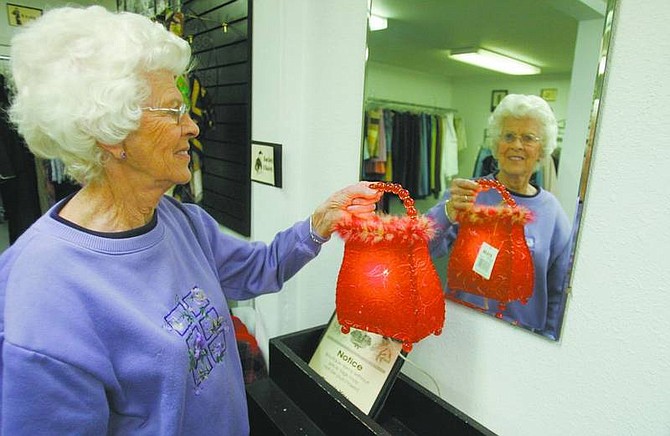 BRAD HORN/Nevada Appeal Harriett Keeran holds a purse that also can used as a lamp in the boutique area of Classy Seconds Thrift Store on Hot Springs Road on Thursday.
