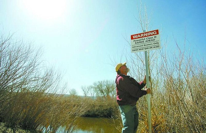 BRAD HORN/Nevada Appeal Steve Crawford, a Carson City parks maintenance worker, positions a warning sign Thursday morning at the &#039;put in&#039; site near the U.S. Bureau of Land Management&#039;s Carson City Field office on Morgan Mill Road. Carson City is posting new information signs on the Carson River this week to advise boaters about whitewater rapids. The signs are part of the Carson River Aquatic Trail Master Plan to make nearly 14 miles of the Carson River safer and more accessible for rafting, kayaking and canoeing. The plan, approved by the Carson City Board of Supervisors, identifies measures to improve public river access areas, create informational signage and remove hazardous obstacles from the river that could injure rafters and kayakers.