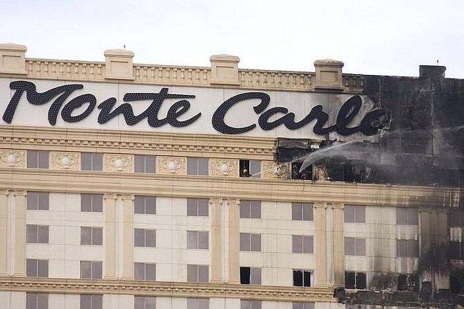 AP Photo/Eric JamisonThe Monte Carlo hotel-casino shows serious damage after a fire is nearly put out Friday in Las Vegas. The fire, which was reported around 11 a.m., spread from the center section of the hotel across the roof before appearing to ease about an hour later.