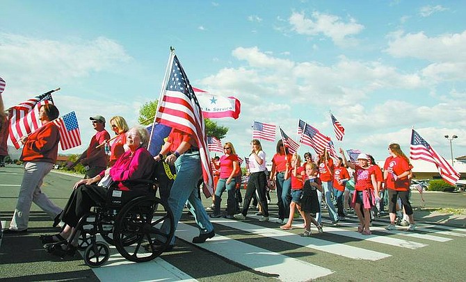 BRAD HORN/Nevada Appeal Jean Amos, in wheelchair, crosses Carson Street with a group honoring American service members on the anniversary of the death of Gardnerville native Chief Warrant Officer Joshua Rodgers. Amos, a resident of Carson City for 28 years, had a husband, grandfather, and son serve in the military.