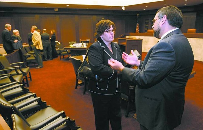 Deputy Attorney General Deonne Contine and attorney Michael Chaudhuri talk Thursday in the Nevada Supreme Court chambers following a hearing in which Contine argued the Legislature mandated all public employers must subsidize retirees who join the plan.  Cathleen Allison/ Nevada Appeal