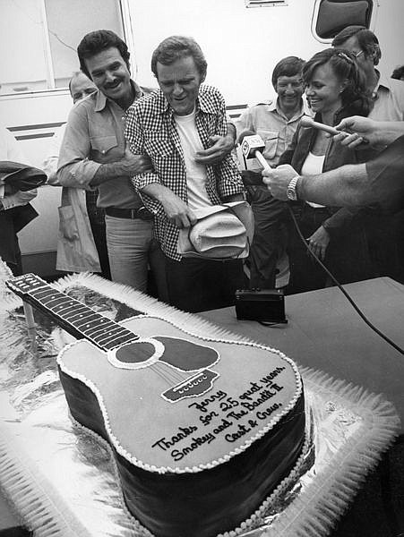 **FILE** In this March 1980 file photo Jerry Reed,center, gets a surprise cake from star Burt Reynolds,left, to commemorate Reed&#039;s 25 years in show business. Reed, best known for appearing in the &quot;Smokey and the Bandit&quot; movies, has died. He was 71. His longtime booking agent says Reed died of complications from emphysema.(AP Photo/File)