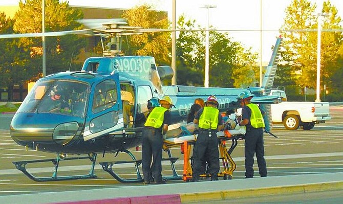 Barry Ginter/Nevada AppealParamedics load a Carson City man into a Care Flight helicopter Monday evening in a parking lot next to Carson High School.