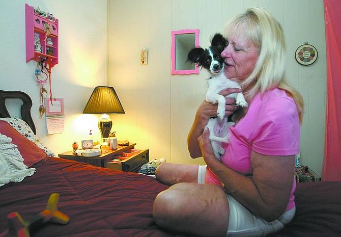 Cathleen Allison/Nevada AppealGina Jones plays with her dog, Lucy, at her home in the Downtowner Motor Inn on Thursday night. Jones, who is on disability, says she makes just enough to stay in the hotel, but not enough to afford utilities and down payment costs that go along with an apartment.