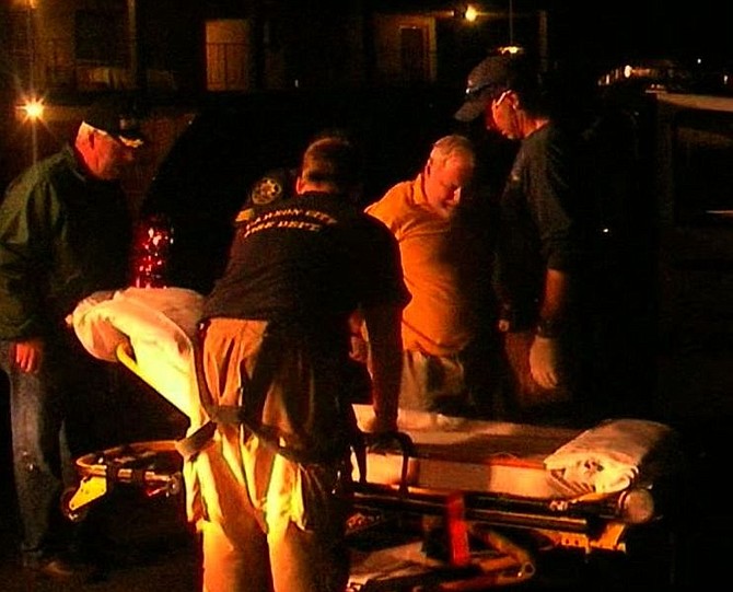 Carson City paramedics help a handcuffed Richard Lanave onto a stretcher to be taken to the hospital. Lanave, 69, allegedly opened fire into his bedroom ceiling, striking a young father asleep upstairs.