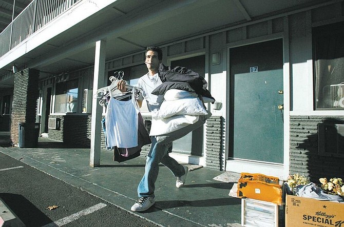 BRAD HORN/Nevada Appeal Steve Helton carries some of his mother&#039;s clothes from their room at the Downtowner Motor Inn on Friday as they prepare to move to the Frontier Motel after the owner of the Downtowner has his business license revoked on Thursday.