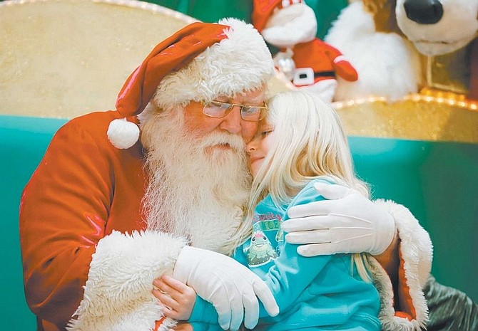BRAD HORN/Nevada Appeal Ainsley Corley, 4, Carson City, hugs Santa Claus after getting her picture taken at the Carson Mall on Friday.