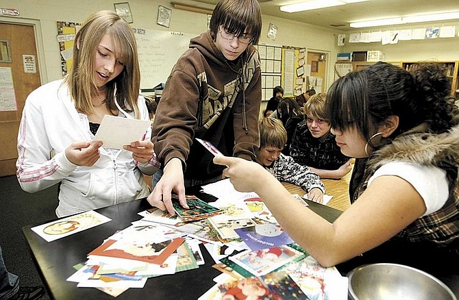 Shannon Litz/Nevada appeal news serviceCarson Valley Middle School eighth-graders Morganne Wright, Kevin Kauffman and Brenda Zepeda choose postcards to write to soldiers in Angela Abawi&#039;s class on Nov. 25.
