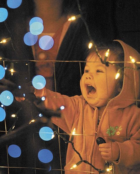 Cathleen Allison/Nevada AppealAbby Rivas, 1, is seen through one of the Christmas trees lit during the Silver &amp; Snowflakes Holiday Tree Lighting ceremony Thursday night at the Capitol. Hundreds of people attended the annual event.