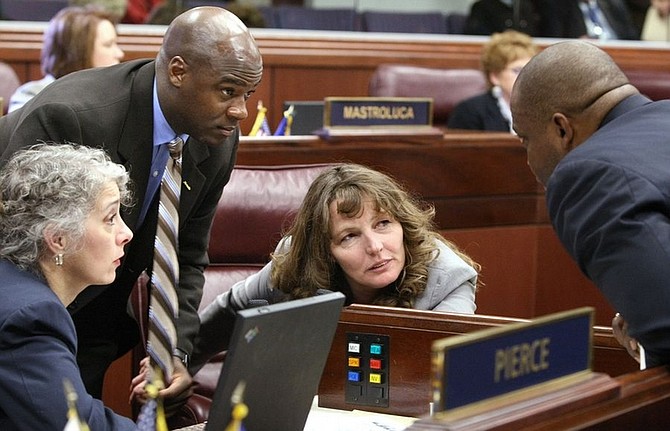 Southern Nevada Assembly democrats, from left, Peggy Pierce, Kelvin Atkinson, Marilyn Kirkpatrick and William Horne talk Monday, Dec. 8, 2008 at the Legislature in Carson City, Nev. Lawmakers convened for a special session to address more budget cuts and tap other sources to cover this fiscal year&#039;s revenue shortfall of more than $340 million. (AP Photo/Cathleen Allison)