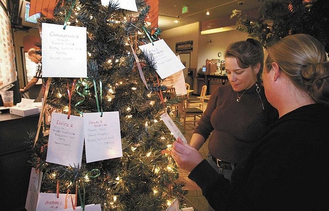 Cathleen Allison/Nevada AppealMolly Cady, right, players club manager at SlotWorld, talks with Tonya Showalter as she choose a card off the Angel Tree recently.
