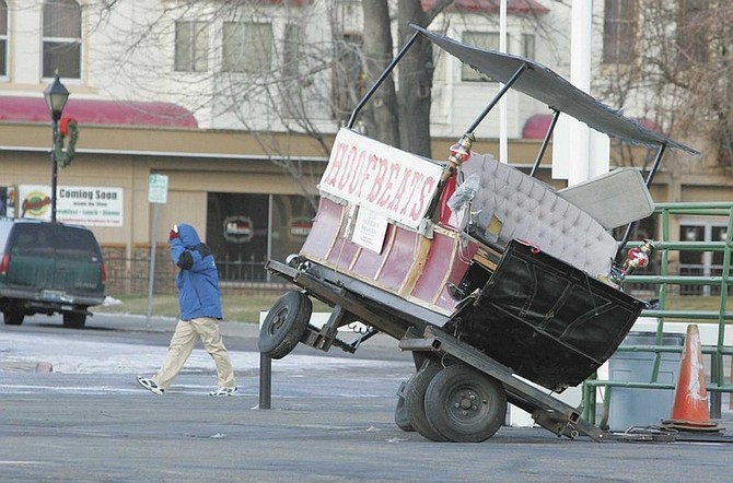 Brad Horn/Nevada AppealA Nugget Casino valet walks past a Hoofbeats carriage that was blown over by the wind in Carson City on Friday morning.