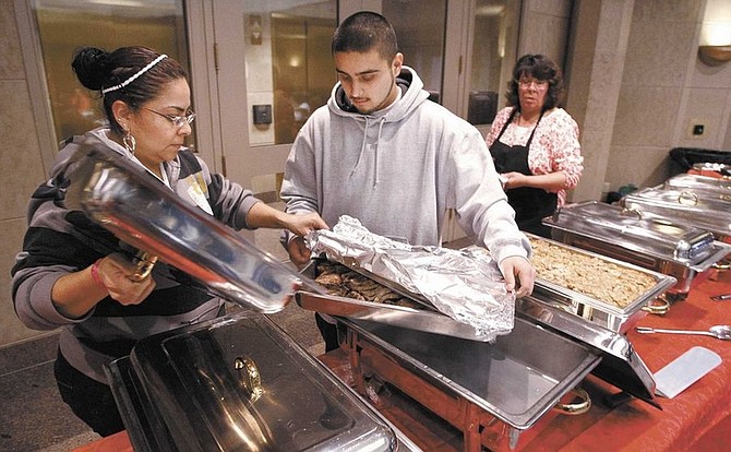 Cathleen Allison/Nevada AppealPlaza Hotel and Conference Center staff, from left, Norma Gonzalez, Martin Garcia and Debbie Coyle set up for an office Christmas party Wednesday at the Supreme Court. Some businesses and state agencies have cut back on holiday parties due to current economic conditions, having a further ripple effect on local caterers and restaurants.