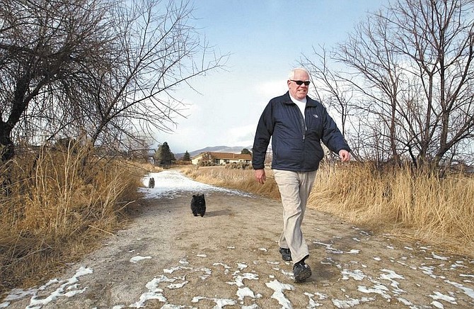 Cathleen Allison/Nevada AppealJohn McKenna walks his dogs Dante and Tobe Thursday afternoon at Riverview Park. McKenna retired after 16 years on the Carson City School Board.