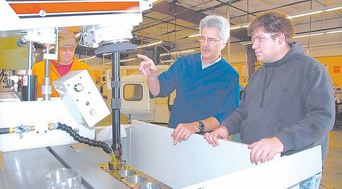 Courtesy PhotoJim Montgomery of the Rottler Manufacturing Company, center, shows the controls to student assistant Matt Digangi, right, for a new computer-guided machine tool at Western Nevada College&#039;s Carson City campus. The new machines have tolerances to one ten-thousandth of an inch and can precisely restore engine blocks.