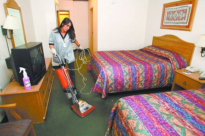 Cathleen Allison/Nevada Appeal  Gold Dust West housekeeper Terry Smith cleans a room Friday morning at the the East Carson City hotel. City businesses and officials are skeptical of a proposal that would increase room taxes to help fund state education.