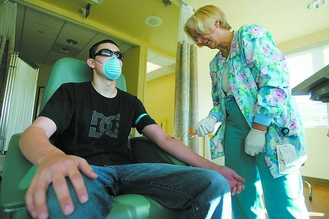 BRAD HORN/Nevada Appeal Rita Waclo, a registerd nurse at Carson Tahoe Regional Medical Center&#039;s Cancer Center, draws blood from Cameron Hardy on Friday morning. Cameron, 19, is battling leukimia and is in desperate need of a bone marrow transplant.