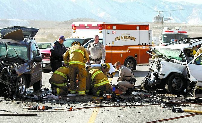 Shannon Litz/Appeal News ServiceMember of the East Fork Fire &amp; Paramedic Districts and the Douglas County Sheriff&#039;s Office work on the driver of the Jeep Grand Cherokee at the scene of the head-on accident Wednesday near Courtland Lane while the Care Flight helicopter lands in the background.