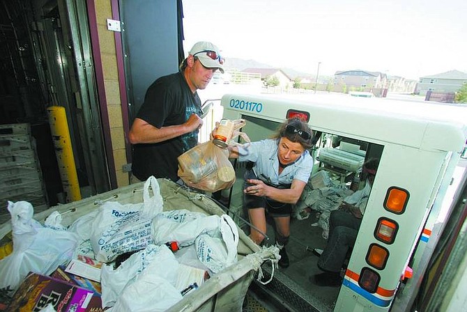 BRAD HORN/Nevada Appeal Carrier Kathleen Michael unloads donated food while FISH volunteer Peter Wagner assists at the Carson City Post Office on Roop Street Saturday during the annual letter carriers&#039; food drive.